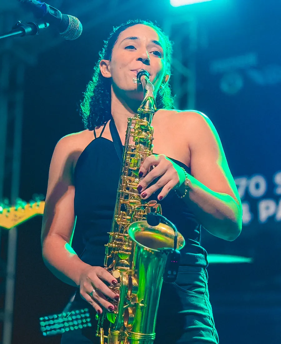 Maria Elis tocando saxofone no show